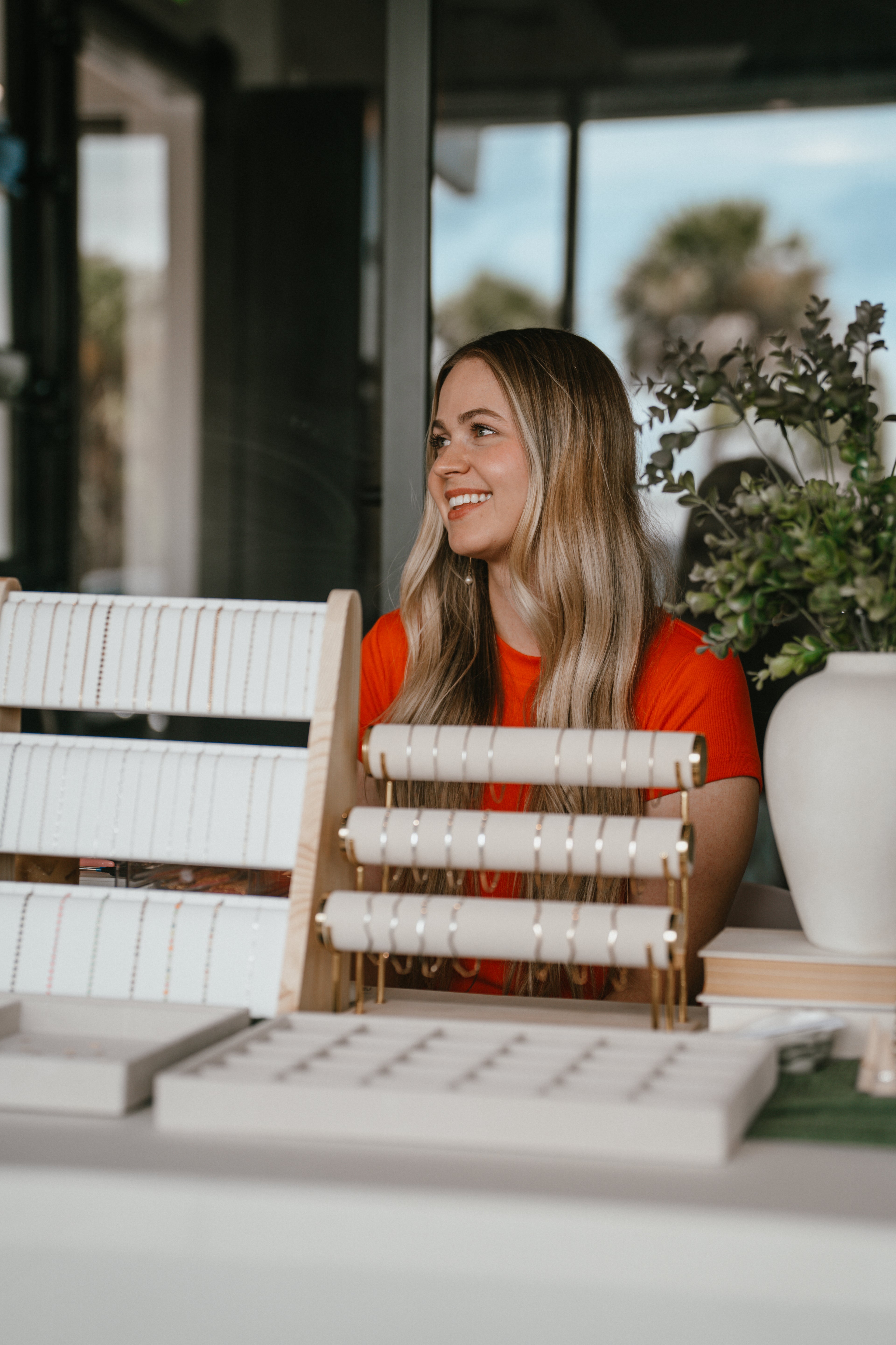 Woman displaying permanent jewelry bracelets at a Pearl & Palm pop-up event